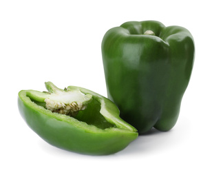 Photo of Whole and cut green bell peppers isolated on white