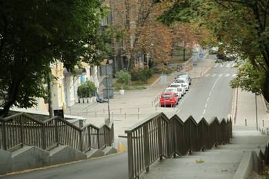 Photo of Picturesque view of quiet street with beautiful stairs, road and trees