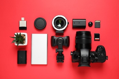 Flat lay composition with camera and video production equipment on red background