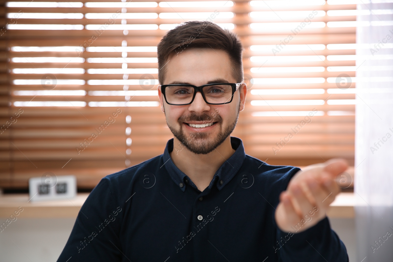 Photo of Happy man using video chat in modern office, view from web camera