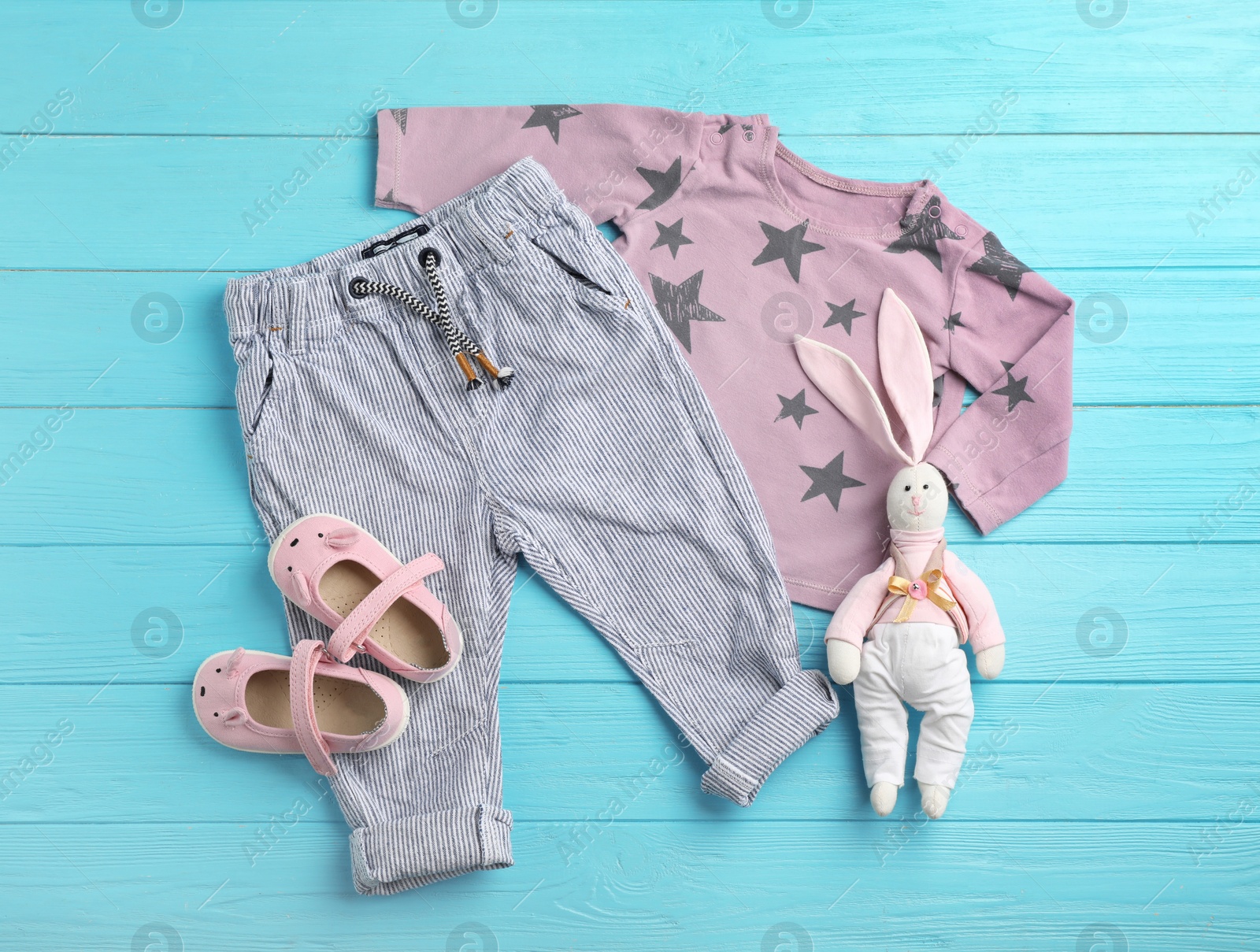 Photo of Flat lay composition with cute clothes on wooden background. Baby accessories