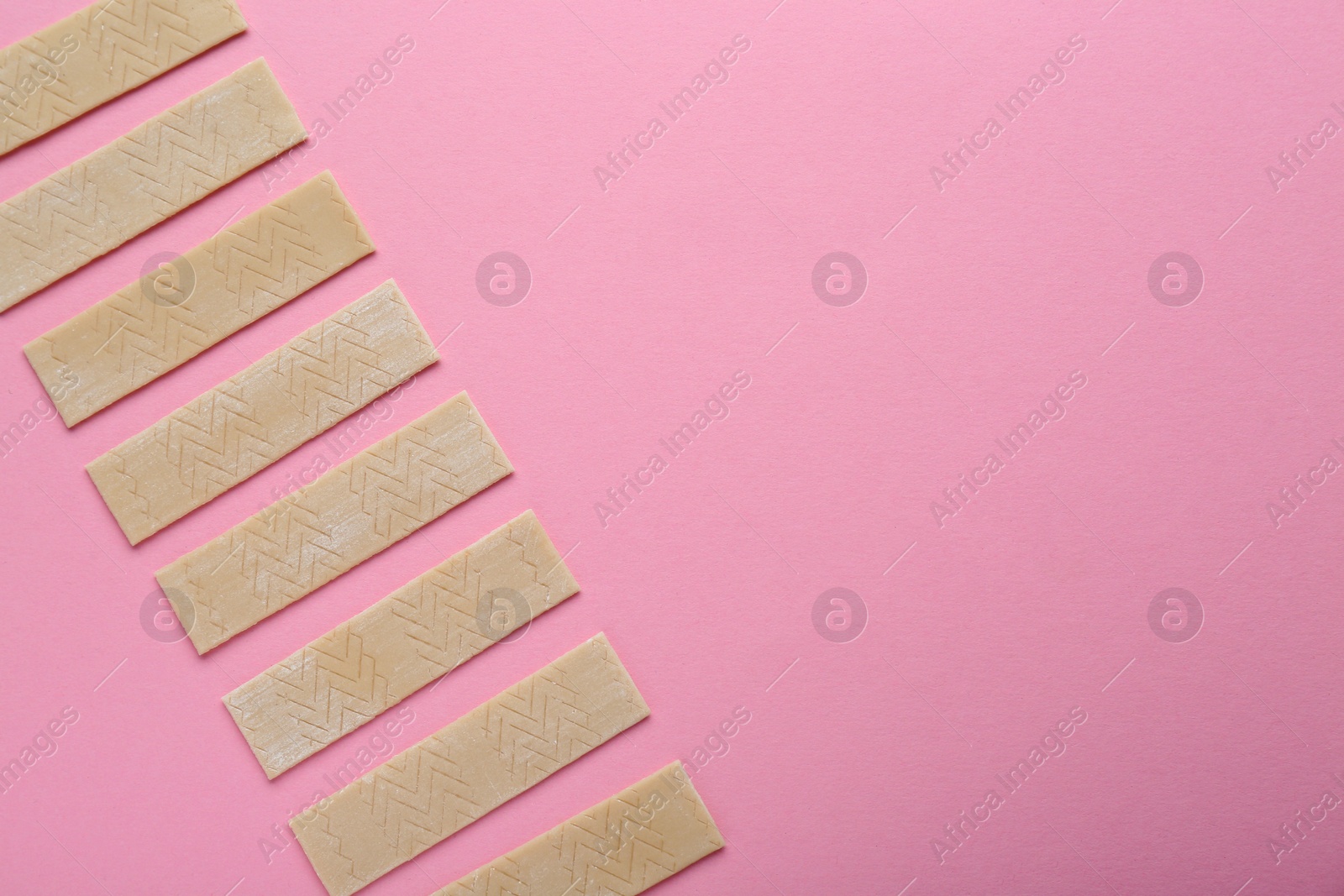 Many sticks of tasty chewing gum on pink background, flat lay. Space for text Photo of Many sticks of tasty chewing gum on pink background, flat lay. Space for text
