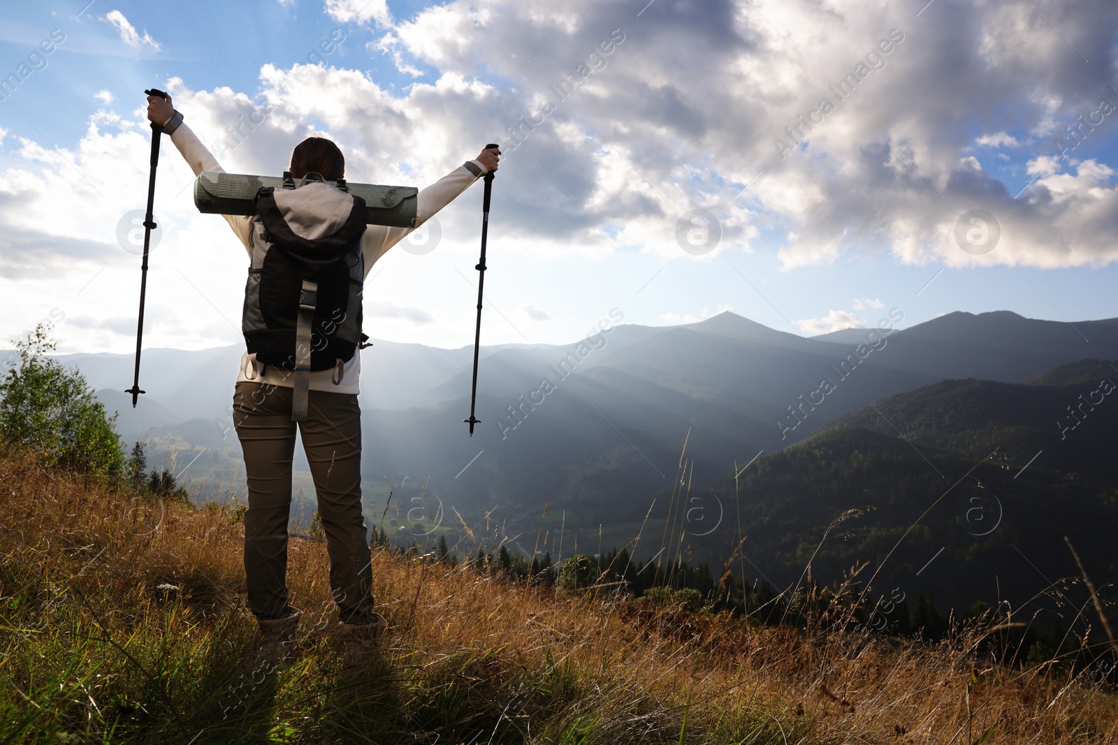 Photo of Triumphant tourist on top of mountain, back view. Space for text