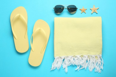 Flat lay composition with different beach objects on light blue background