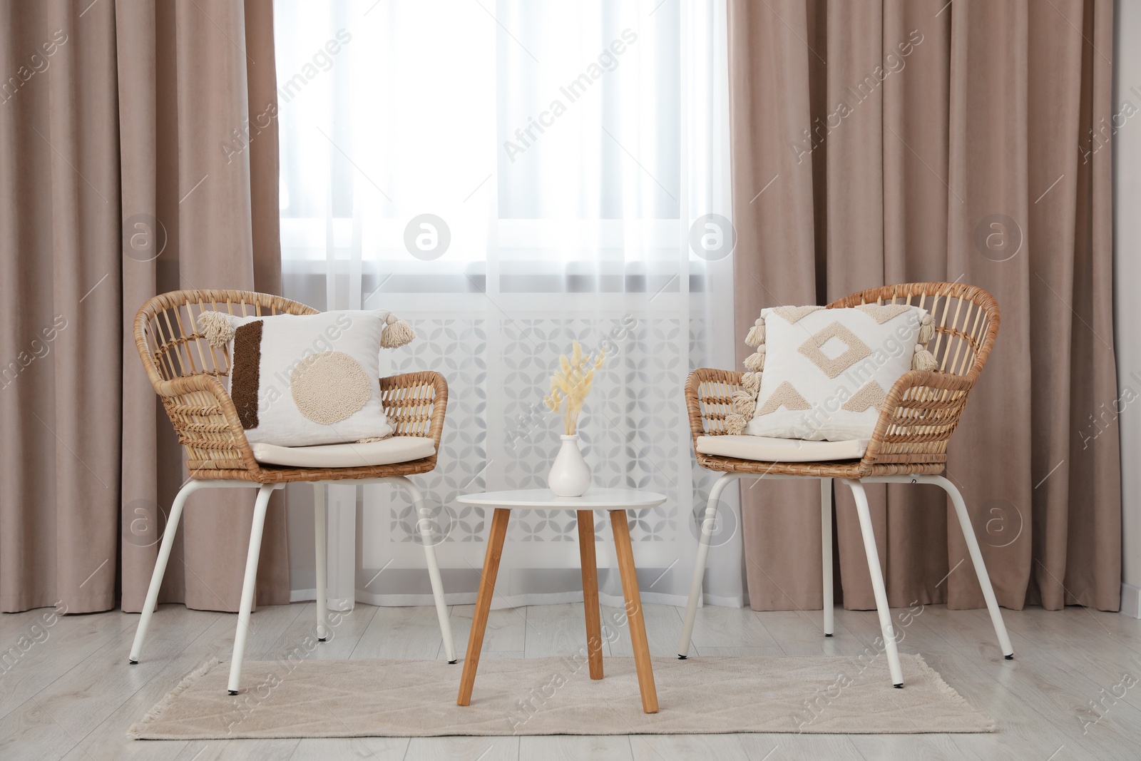 Photo of Living room with pastel window curtains, wooden table and rattan chairs