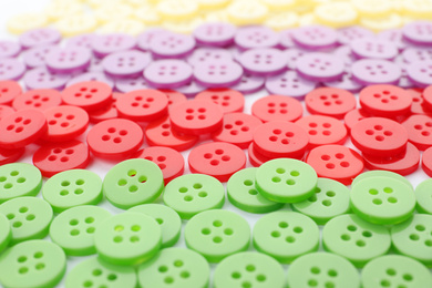 Photo of Many colorful plastic sewing buttons as background, closeup