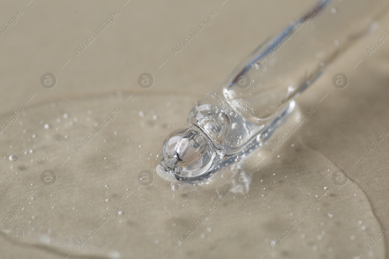 Photo of Pipette with cosmetic serum on beige background, macro view. Space for text