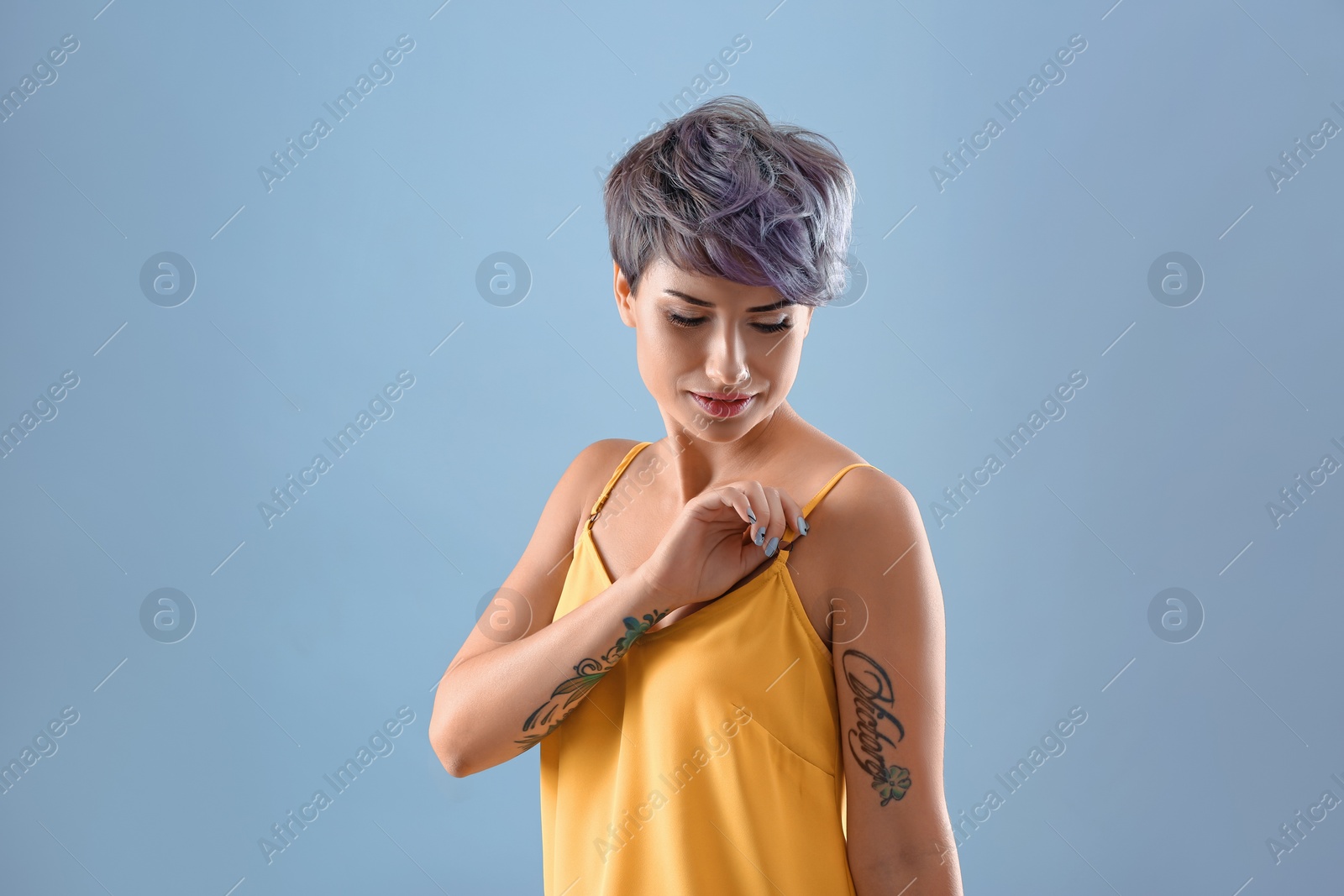 Photo of Young woman with tattoos on color background