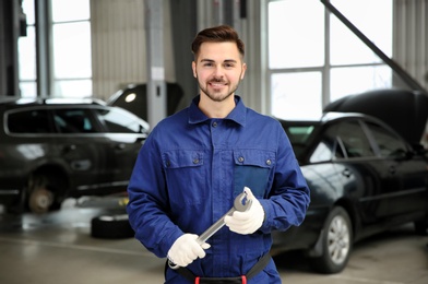 Photo of Portrait of technician with wrench at automobile repair shop