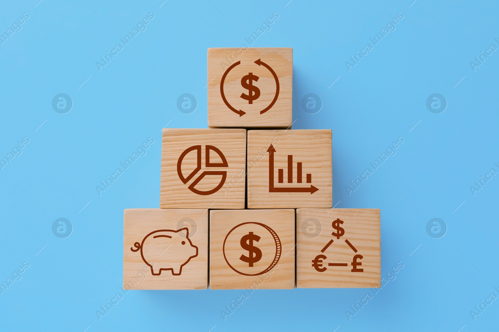Image of Pyramid made of wooden cubes with different images on light blue background, flat lay. Management concept