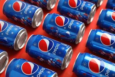 Photo of MYKOLAIV, UKRAINE - FEBRUARY 08, 2021: Cans of Pepsi on red background