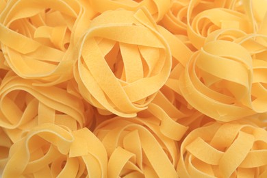 Photo of Raw tagliatelle pasta as background, top view