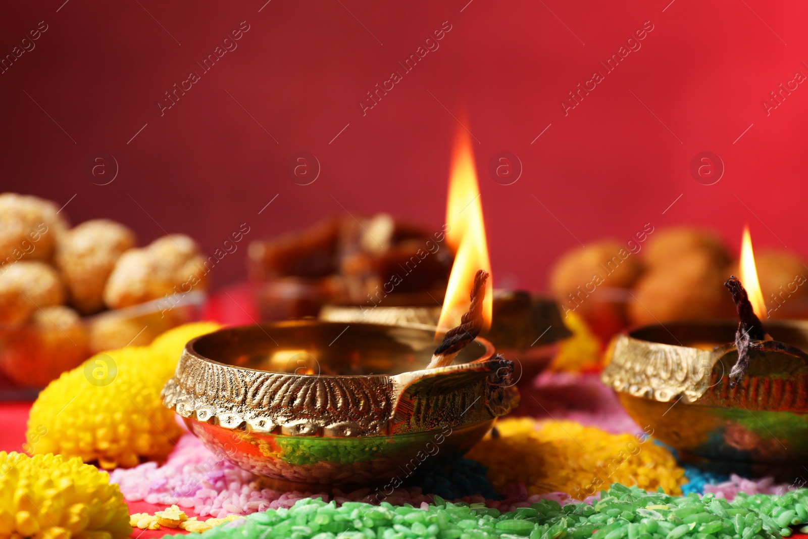 Photo of Happy Diwali. Diya lamps, colorful rangoli and flowers on table, closeup