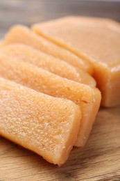 Photo of Tasty sweet quince paste on wooden board, closeup