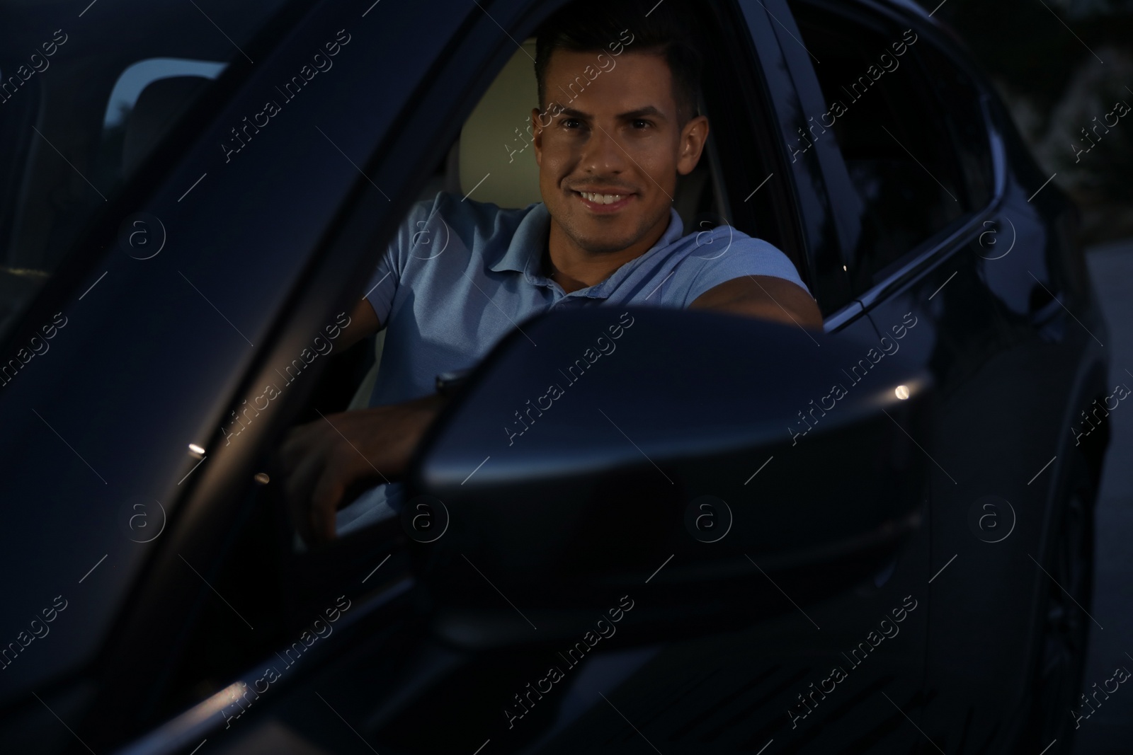 Photo of Handsome man in his modern car, view from outside