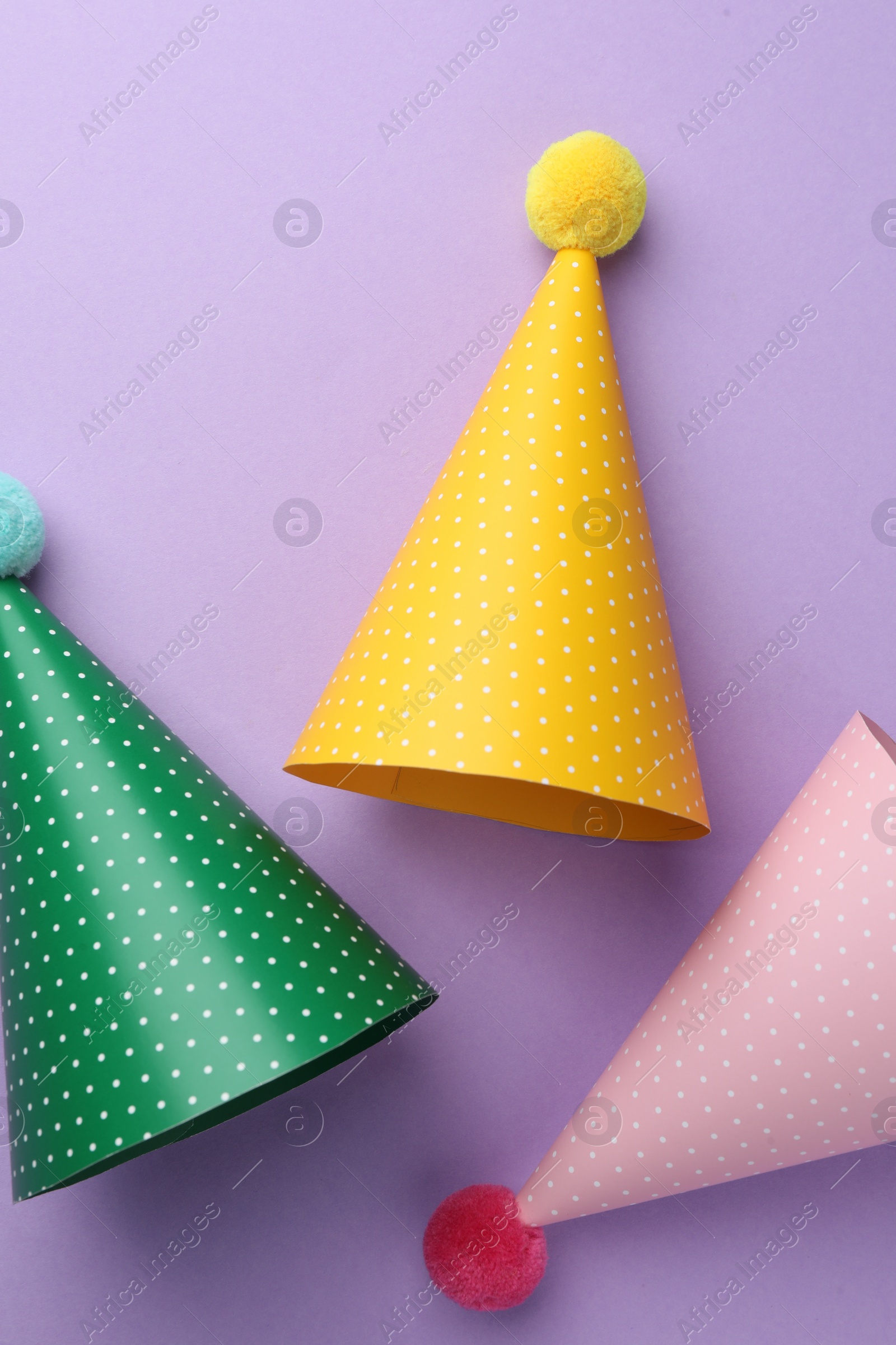 Photo of Beautiful party hats on purple background, top view