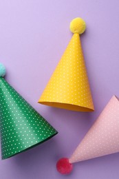 Photo of Beautiful party hats on purple background, top view