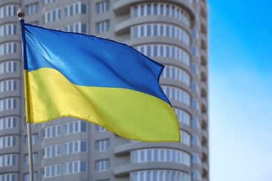 Photo of National flag of Ukraine fluttering near building on sunny day