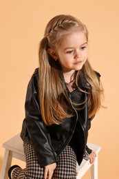 Fashion concept. Stylish girl posing on pale orange background