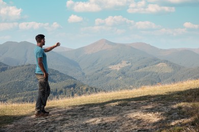 Man enjoying picturesque mountain landscape. Space for text