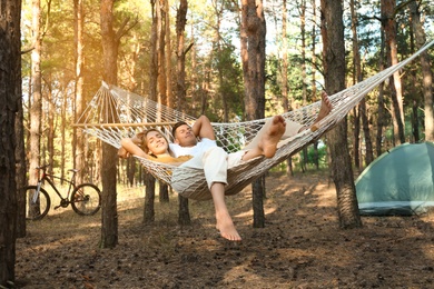 Happy couple resting in hammock outdoors on summer day