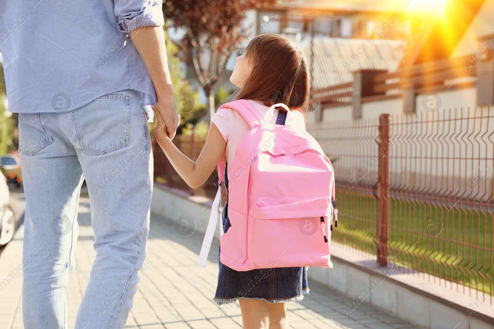 Image of Father taking his little child to school on street