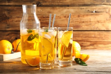 Delicious refreshing drink with orange slices on wooden table