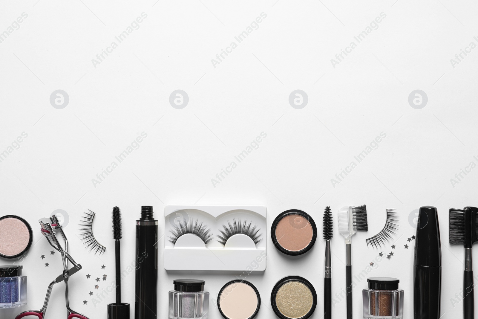 Photo of Composition with false eyelashes and other makeup products on white background, top view