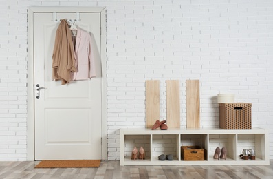 Hallway interior with shoe rack and mat near door