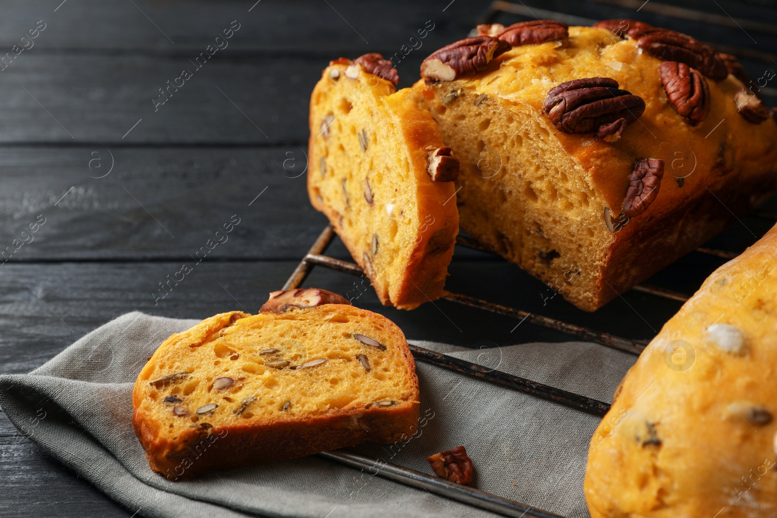 Photo of Delicious pumpkin bread with pecan nuts on black wooden table, closeup. Space for text