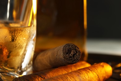 Photo of Cigars, glass and bottle of whiskey, closeup