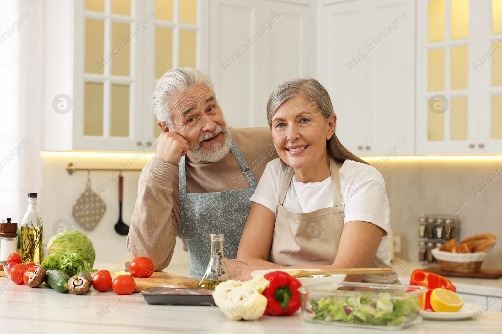 Photo of Happy senior couple at table in kitchen