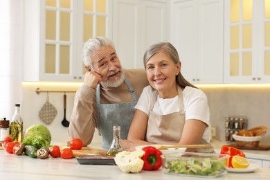 Happy senior couple at table in kitchen