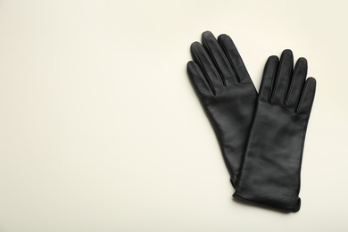 Photo of Pair of stylish leather gloves on beige background, flat lay. Space for text
