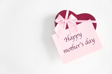 Gift box and card with words "Happy Mother's Day" on light background, top view