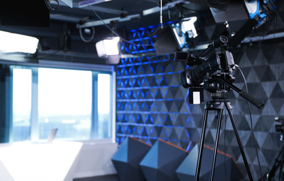 Photo of Modern video recording studio with professional equipment, focus on camera