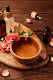 Photo of Bowlessential oil and beautiful roses on wooden table. Aromatherapy treatment