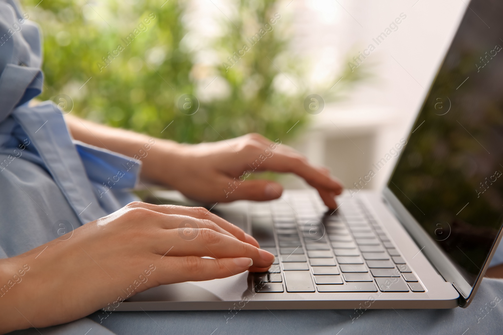 Photo of Woman working with modern laptop indoors, closeup