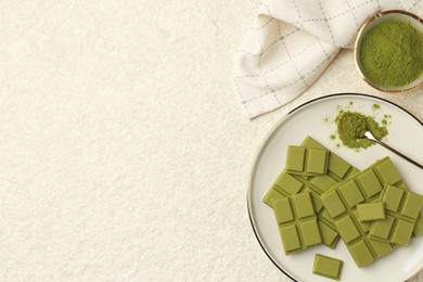 Photo of Pieces of tasty matcha chocolate bar and powder on white textured table, flat lay. Space for text