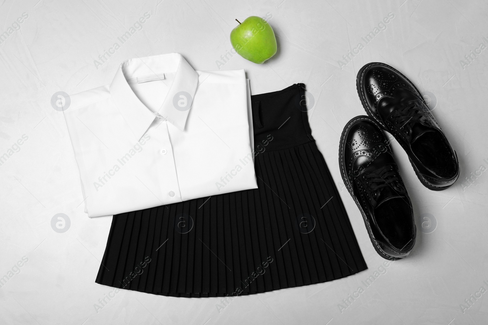 Photo of Flat lay composition with school uniform on light background