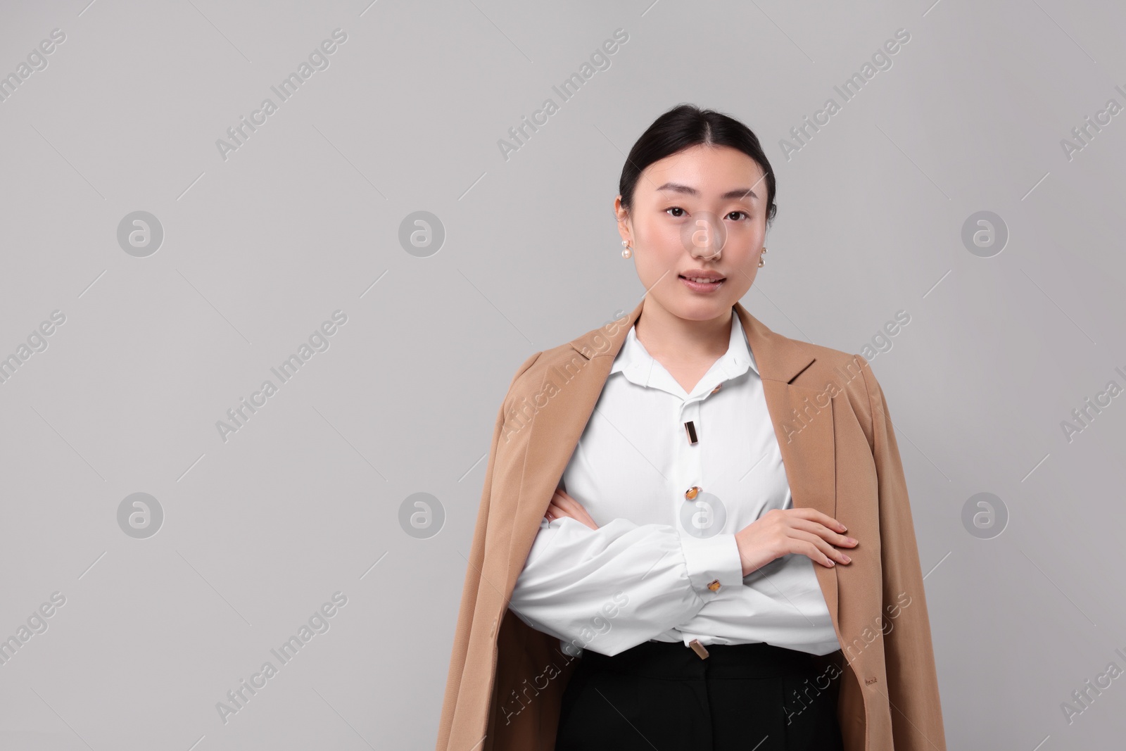 Photo of Portrait of beautiful businesswoman on grey background. Space for text