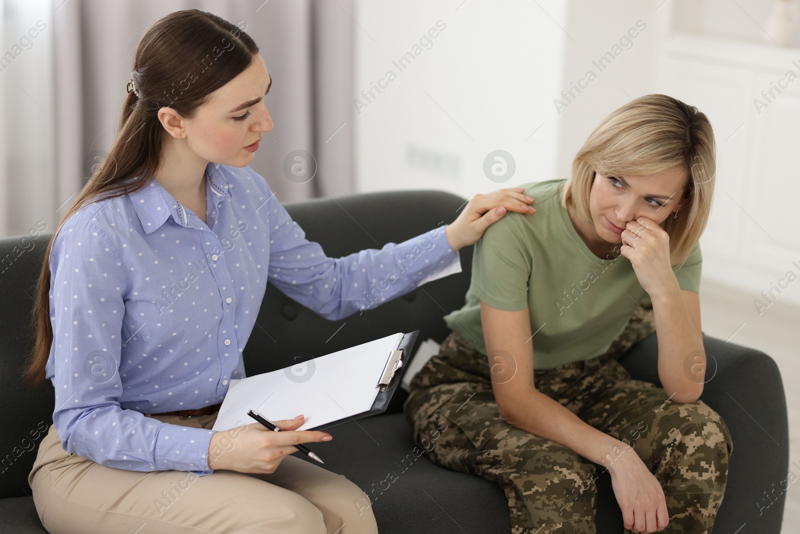 Photo of Psychotherapist working with military woman on sofa in office