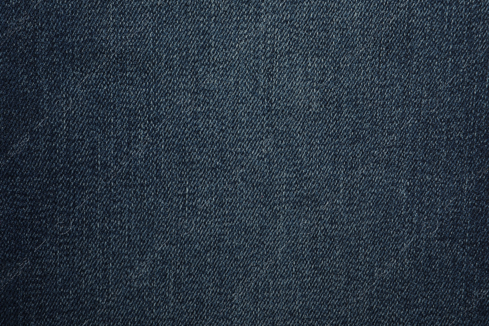 Photo of Texture of dark blue jeans as background, closeup