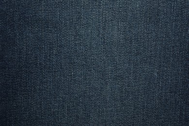 Texture of dark blue jeans as background, closeup