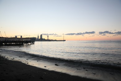 Photo of Picturesque view of pier in sea under beautiful sky at sunset