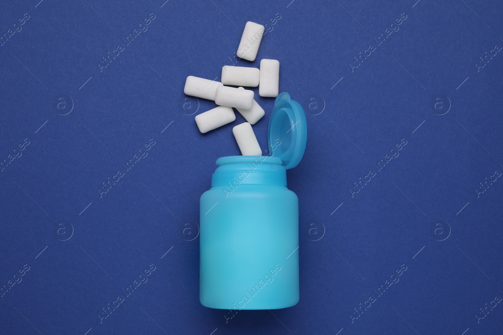 Photo of Jar with chewing gums on blue background, flat lay