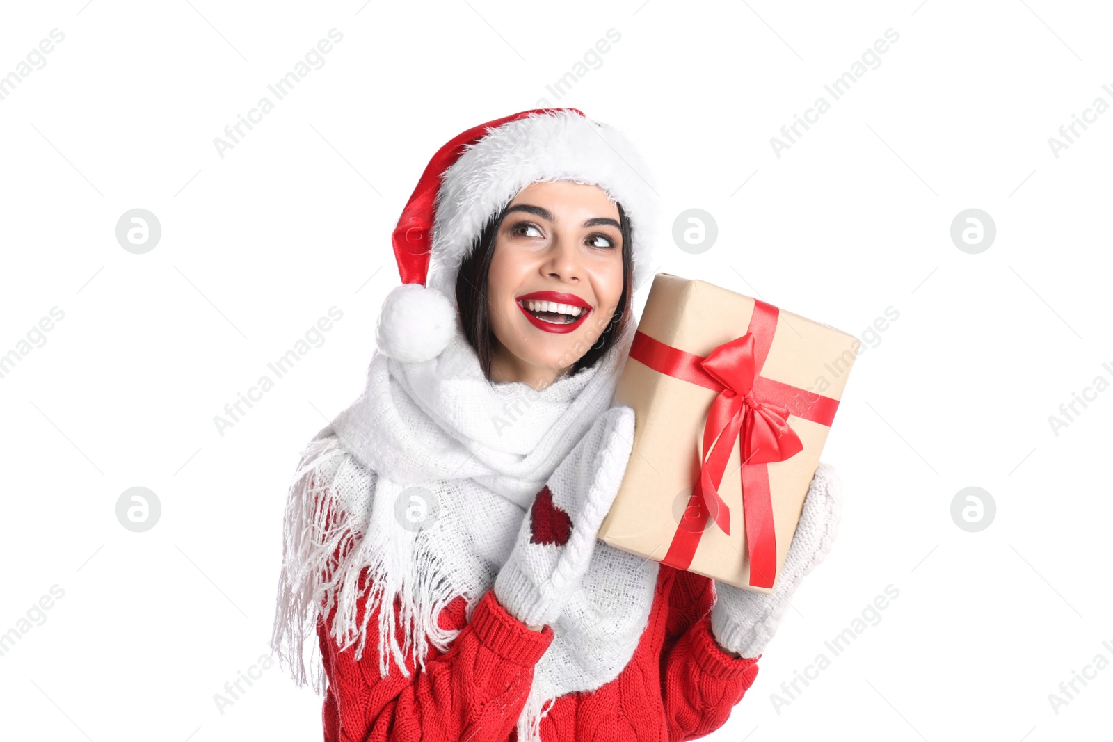 Photo of Woman in Santa hat, knitted mittens, scarf and red sweater holding Christmas gift on white background