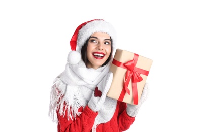 Photo of Woman in Santa hat, knitted mittens, scarf and red sweater holding Christmas gift on white background
