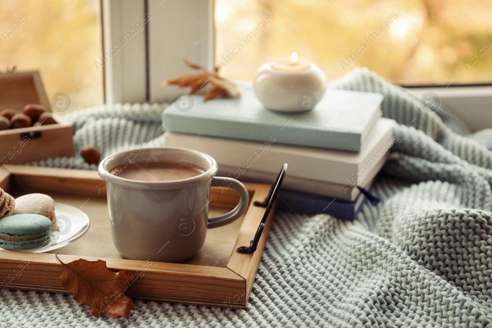 Photo of Tray with breakfast near stack of books on windowsill