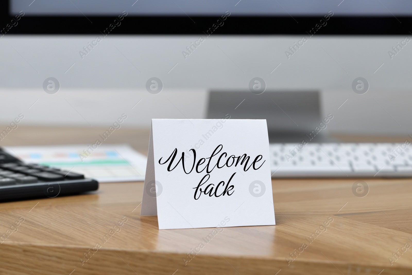 Image of Paper note with phrase Welcome Back on office desk